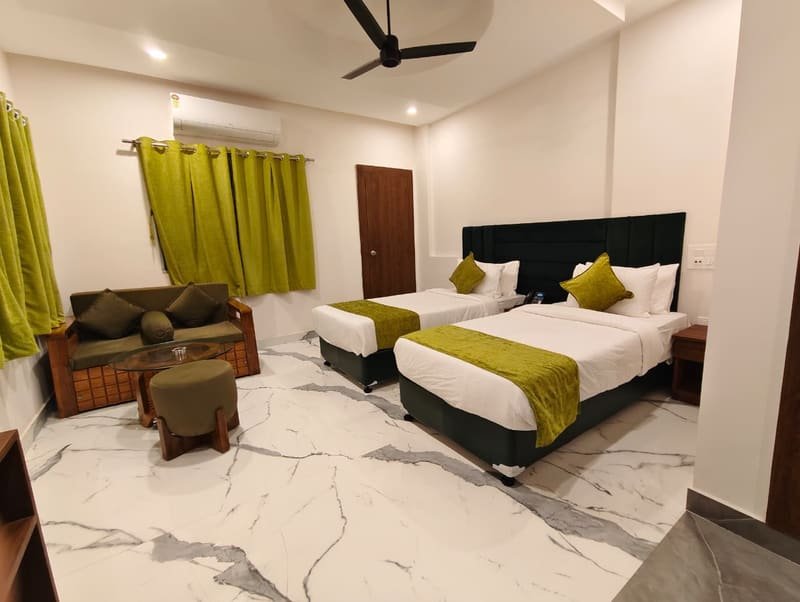 Twin beds on a marble floor with green curtains drawn back